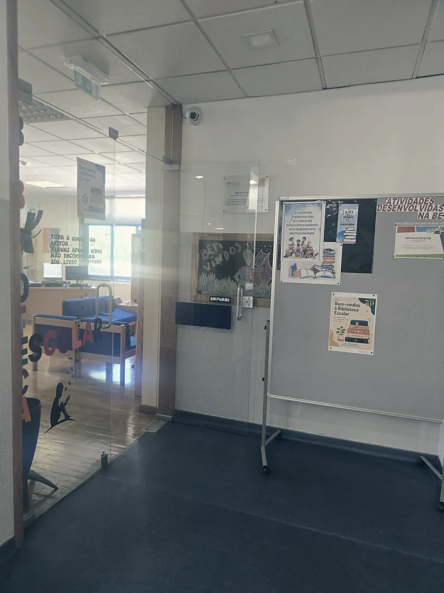 Entrada da biblioteca, com as letras «Biblioteca Escolar» na porta de vidro